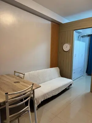 a living room with a couch and a table and a clock at Cozy home in Manila