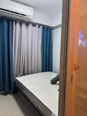 a bed in a room with blue curtains at Cozy home in Manila