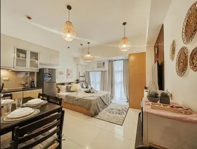 a room with a bed and a kitchen with a table at Studio Unit McKinleyHill near Venice Grand Canal in Manila