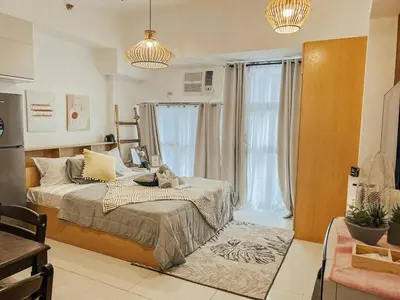 a bedroom with a bed and a large window at Studio Unit McKinleyHill near Venice Grand Canal in Manila