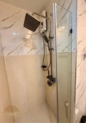 a shower with a shower head in a bathroom at 2BR Luxe Staycation in Charm Residences in Manila