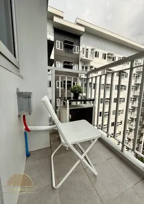 a white chair sitting on top of a balcony at 2BR Luxe Staycation in Charm Residences in Manila