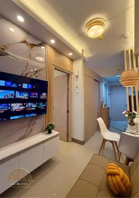 a living room with a flat screen tv on a wall at 2BR Luxe Staycation in Charm Residences in Manila