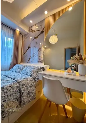 a bedroom with a bed and a desk and a chair at 2BR Luxe Staycation in Charm Residences in Manila