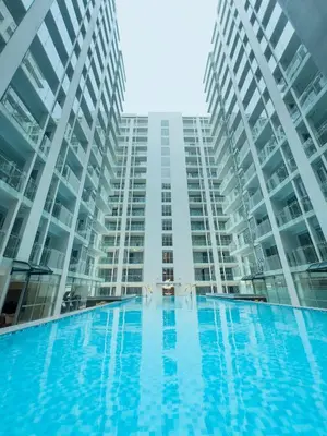 a large apartment building with a large swimming pool at Spacious 12-Pax Stay Near Airport, City of Dreams, Okada, Ayala Malls, MOA & Solaire in Manila