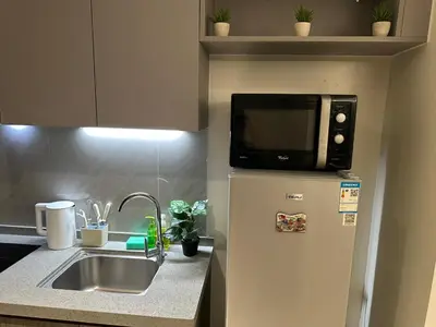 a microwave on top of a refrigerator in a kitchen at Spacious 12-Pax Stay Near Airport, City of Dreams, Okada, Ayala Malls, MOA & Solaire in Manila
