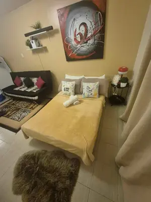 a room with a bed and a chair in it at B&C studio in Manila