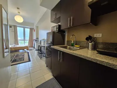a kitchen with a refrigerator and a sink in a room at B&C studio in Manila