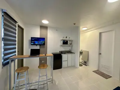 a kitchen with a bar with two stools in a room at Stylish Minimalist Comfort Stay Beside EK in Santa Rosa