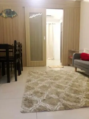 a living room with a rug on the floor at Shore Residence Tower C2 in Manila
