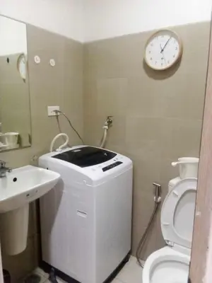 a bathroom with a toilet and a clock on the wall at Shore Residence Tower C2 in Manila