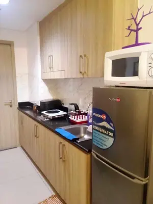 a kitchen with a stainless steel refrigerator and a microwave at Shore Residence Tower C2 in Manila