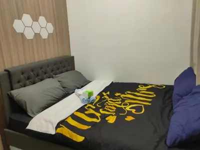 a bed with a black and yellow blanket on it at Shore Residence Tower C2 in Manila