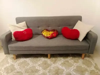 three heart cushions sitting on a couch at Shore Residence Tower C2 in Manila