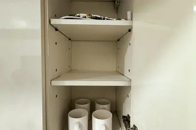 a closet with white shelves and toilets in it at KL Studio close to Greenbelt in Manila