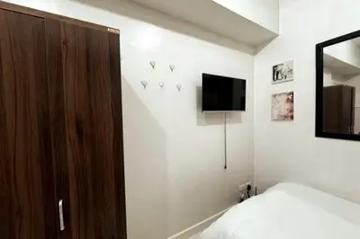 a bedroom with a bed and a tv on the wall at KL Studio close to Greenbelt in Manila