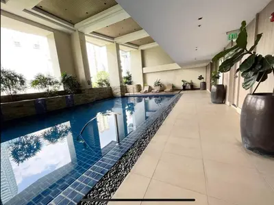 a large swimming pool in a hotel lobby with at KL Studio close to Greenbelt in Manila
