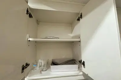a small kitchen with a white cabinet with a sink at KL Studio close to Greenbelt in Manila
