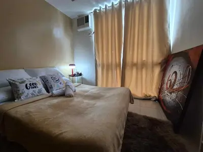 a bedroom with a bed with pillows and a window at B&C Studio Kasara Urban Resort Residences in Manila