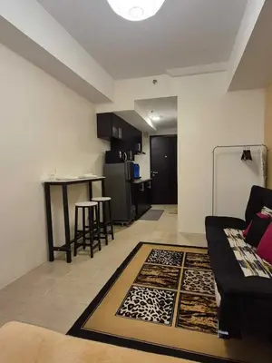 a living room with a couch and a kitchen at B&C Studio Kasara Urban Resort Residences in Manila