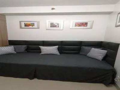 a couch in a living room with pillows on it at The Donegal with WI-FI Netflix Parking with fee in Manila