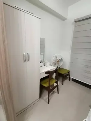 a white room with a desk and a chair with a fan at The Donegal with WI-FI Netflix Parking with fee in Manila