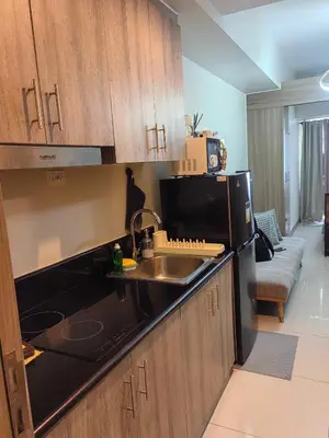 a kitchen with a sink and a refrigerator at AHD Staycation in Manila