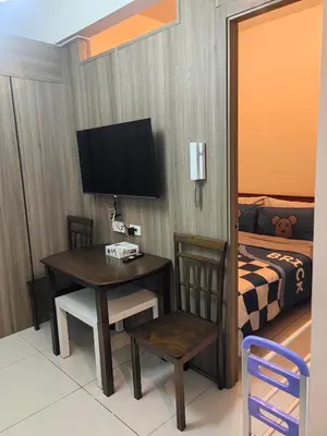 a room with a desk and a bed and a television at AHD Staycation in Manila