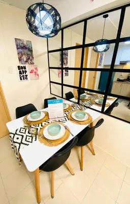 a dining room with a table with chairs and a tableweredktop at 1Haven in Pasig CCF Bridgetown in Manila