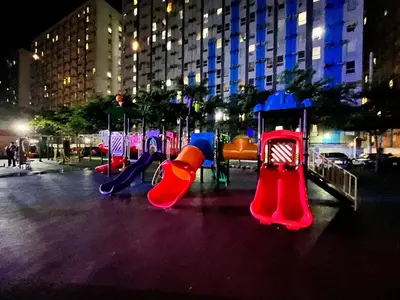 a row of playground equipment in a city at night at 1Haven in Pasig CCF Bridgetown in Manila