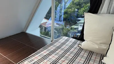 a bed in a room with a large window at Noirescape in Binangonan