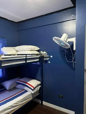 a room with a bunk bed with a blue wall at Noirescape in Binangonan