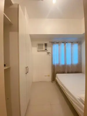 a small room with a bed and a window at Light Residence Condo with Pool View in Manila