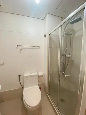 a bathroom with a toilet and a shower at Light Residence Condo with Pool View in Manila