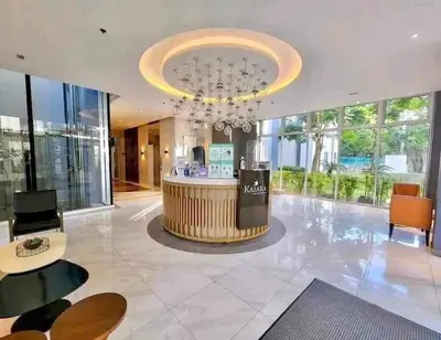 a large lobby with a chandelier and a bar at B&C Studio Kasara Urban Resort Residences in Manila