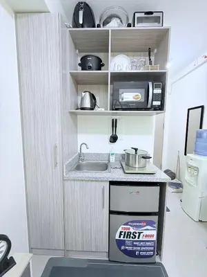 a kitchen with a stove and a microwave at Michaels Cozy Retreat in Cubao in Manila
