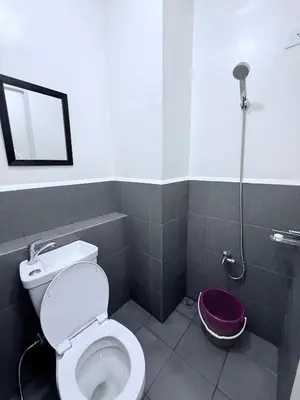 a bathroom with a toilet and a shower at Michaels Cozy Retreat in Cubao in Manila