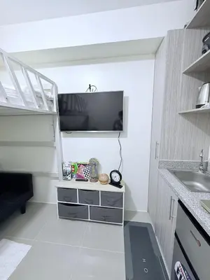 a kitchen with a sink and a tv on the wall at Michaels Cozy Retreat in Cubao in Manila