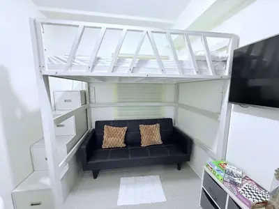 a small living room with a couch under a loft bed at Michaels Cozy Retreat in Cubao in Manila