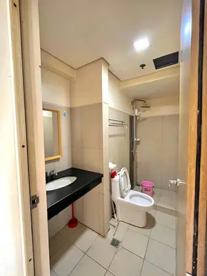 a bathroom with a toilet and a sink at Breeze Deluxe moa view 6pax in Manila