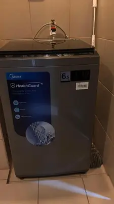 a washing machine sitting on the floor in a bathroom at DH Suites in Manila
