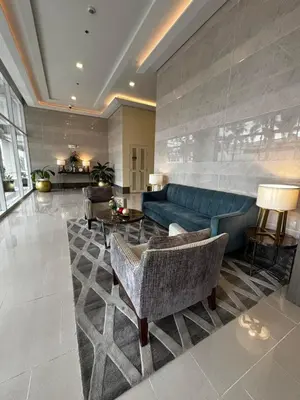 a large living room with a blue couch and chairs at DH Suites in Manila