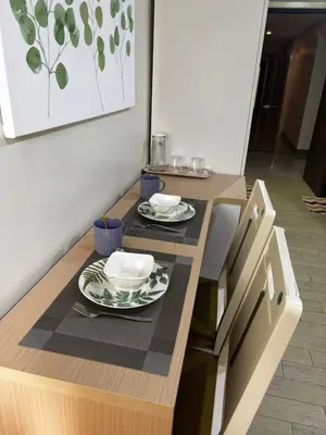 a kitchen with a table with plates and dishes on it at DH Suites in Manila