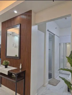 a bathroom with a mirror and a wooden wall at Modern Minimalist 1BR Condotel at BGC Taguig in Taguig