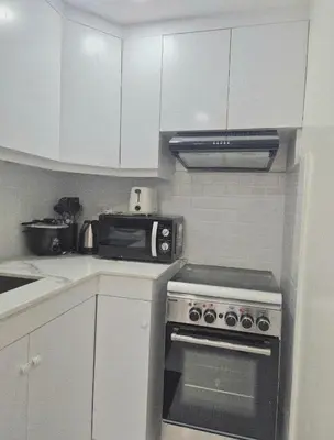 a kitchen with a stove and a microwave at Modern Minimalist 1BR Condotel at BGC Taguig in Taguig
