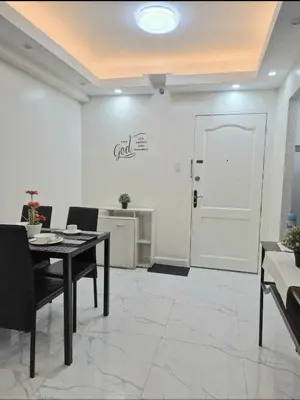 a dining room with a table and a white door at Modern Minimalist 1BR Condotel at BGC Taguig in Taguig