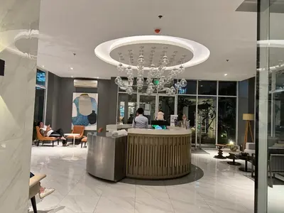 a lobby with a reception desk and a chandelier at Comfy Spot Staycation Studio at Kasara Urban Pasig in Manila