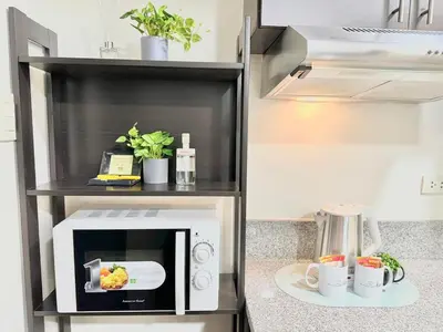 a microwave on a shelf in a kitchen at Comfy Spot Staycation Studio at Kasara Urban Pasig in Manila
