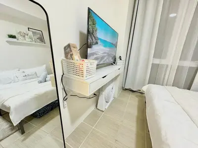 a mirror in a bedroom with a tv and a bed at Comfy Spot Staycation Studio at Kasara Urban Pasig in Manila
