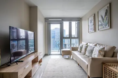 a living room with a couch and a flat screen tv at Uptown Parksuites BGC Stylish 2BR Fast WiFi Washer Balcony in Manila